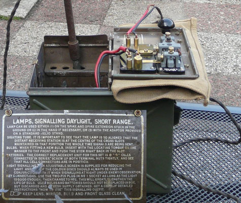 Morse signalling lamp with a very narrow beam and a Morse key unit which can be mounted on a staked in the ground provided in the carrying case.