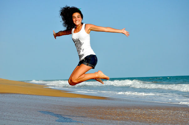 Bewegung, Frau springt am Strand