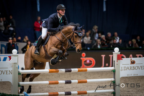 Munich Indoors - Springreiten - Pferd mit Reiter beim Sprung über ein Hindernis
