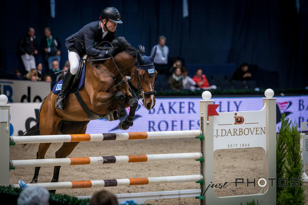 Munich Indoors - Springreiten - Pferd mit Reiter beim Sprung über ein Hindernis