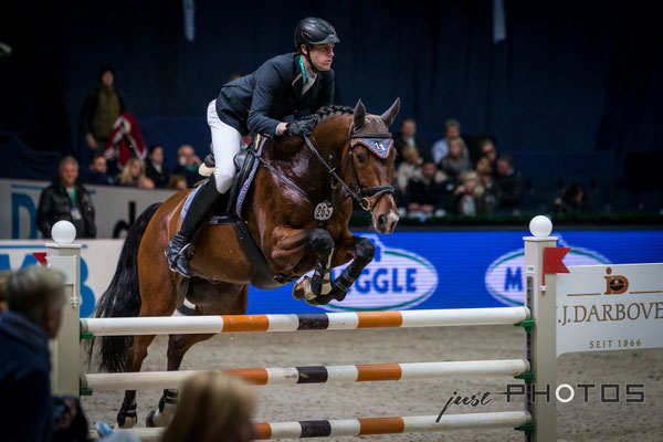 Munich Indoors - Springreiten - Pferd mit Reiter beim Sprung über ein Hindernis