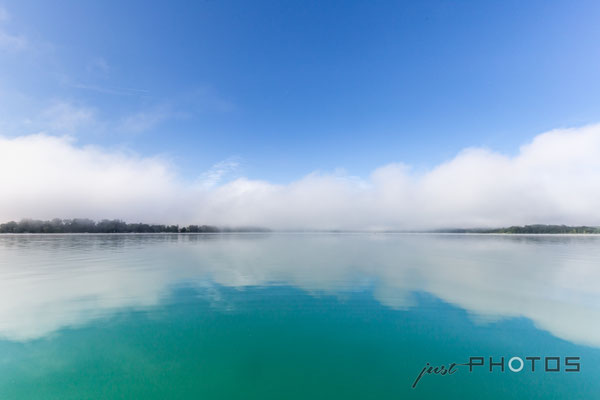 Nebelstimmung am Wörthsee (Nebelwand lichtet sich, der blaue Himmel spiegelt sich im türkisen Wasser)