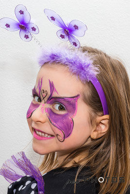 Mädchen - geschminkt mit lilia Schmetterling auf dem Gesicht