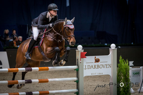 Munich Indoors - Springreiten - Pferd mit Reiter beim Sprung über ein Hindernis