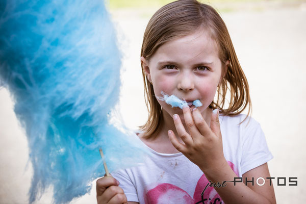 Mädchen isst hellblaue Zuckerwatte