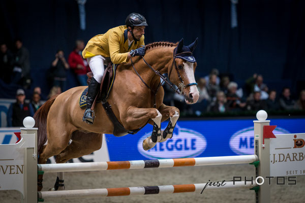 Munich Indoors - Springreiten - Pferd mit Reiter beim Sprung über ein Hindernis