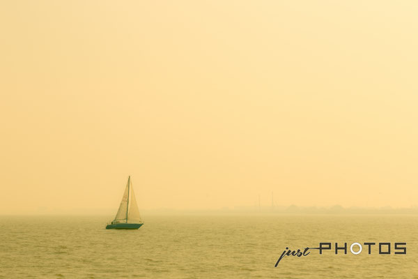 Segelboot in gelbem Nebel (Dunst)