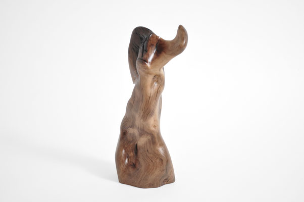 ertical biomorphic wooden sculpture mounted on a square concrete base, created by Jörg Pietschmann, showcasing warm grain patterns on a white background.