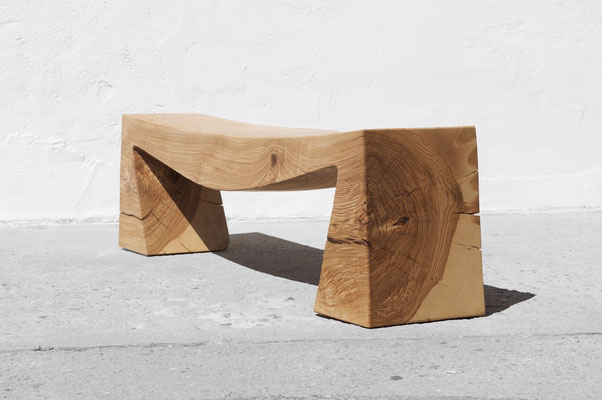 Monolithic gallery bench B1098 in robust ash – a commanding art furniture centerpiece by Jörg Pietschmann, mindfully sculpted to preserve the raw, tectonic fractures of the trunk and anchor the unyielding spirit of the wildwood.