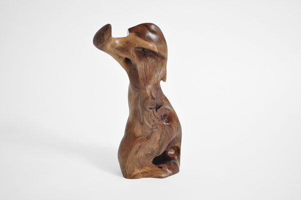 ertical biomorphic wooden sculpture mounted on a square concrete base, created by Jörg Pietschmann, showcasing warm grain patterns on a white background.