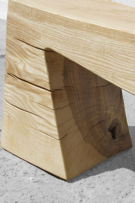 Monolithic gallery bench B1098 in robust ash – a commanding art furniture centerpiece by Jörg Pietschmann, mindfully sculpted to preserve the raw, tectonic fractures of the trunk and anchor the unyielding spirit of the wildwood.