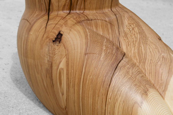 organic ash wood sculpture V1568 by Jörg Pietschmann. The smoothly carved piece evokes the intimate, protective curves of a woman's lap, featuring a prominent circular cavity at the top and flowing grain on a concrete floor.