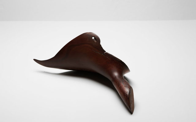 Abstract tropical driftwood sculpture S0137 by Jörg Pietschmann, featuring a sleek, dark brown biomorphic shape resembling a stylized bird or saddle with smooth curves and a natural grain finish on a white studio background.