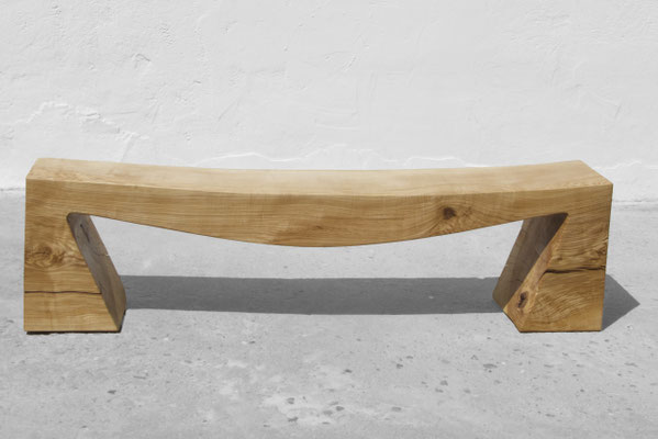 Monolithic gallery bench B1098 in robust ash – a commanding art furniture centerpiece by Jörg Pietschmann, mindfully sculpted to preserve the raw, tectonic fractures of the trunk and anchor the unyielding spirit of the wildwood.