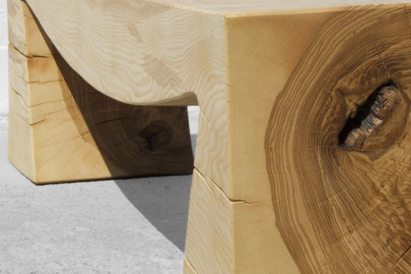 Monolithic gallery bench B1098 in robust ash – a commanding art furniture centerpiece by Jörg Pietschmann, mindfully sculpted to preserve the raw, tectonic fractures of the trunk and anchor the unyielding spirit of the wildwood.
