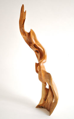 Abstract willow wood sculpture S0198 by Jörg Pietschmann, featuring a tall, flame-like vertical shape with smooth curves, natural openings, and a polished warm honey-brown texture.