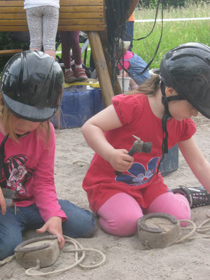 Zwei Mädchen spielen im Sand mit dem Spielhufen.