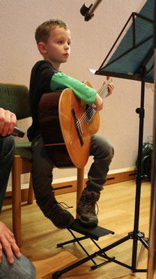 Florian (7 ) zupft an der Gitarre "Morgen kommt der Weihnachtsmann" ....