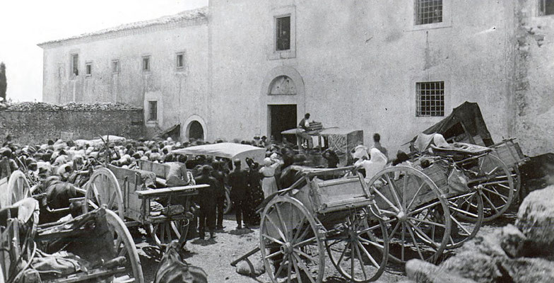 "Anno 1919. Padre Pio che dalla finestra del Coro benedice la folla sul piazzale della Chiesa. Nota. I carretti allora rimpiazzavano gli automobili, che in quei tempi non erano tanto in uso come oggi" (p. Paolino da Casacalenda)