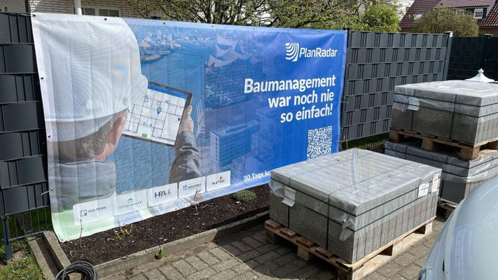Bedrucktes Mesh-Banner am Bauzaun für winddurchlässige Baustellenwerbung