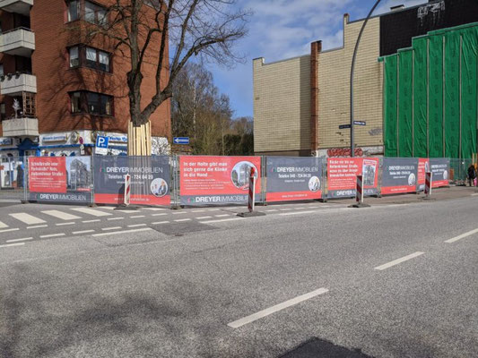 Mehrere Mesh-Banner am Bauzaun für großflächige Baustellenwerbung