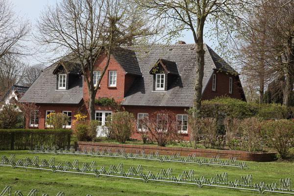 Blick vom roten Haus auf die Fahrradständer und das Haus Passat