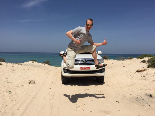 Auto-Jump an einem einsamen Strand in Oman, 2016