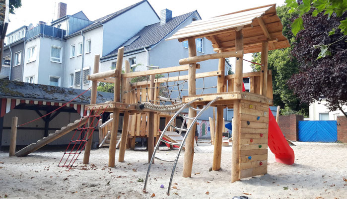 Rutschen und Spielturm aus Robinie mit Wacklebrücke und Rutsche. Angebunden an Bogenleiter Kletterwand und Balancierstamm.