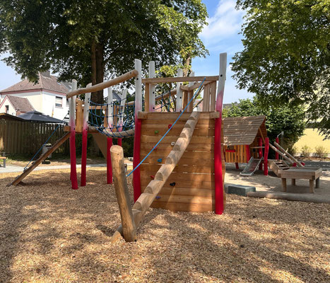 Große Spielanlage aus zwei 3-eck Spieltürmen aus Robinie mit Rutsche und Kletteraufgängen verbunden mit Brücke.