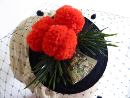 Black sinamay base with red pompoms and a vintage cow bell €59