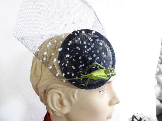 Black sinamay base with white dotted black tulle, decorated with a cute little green and black grasshopper €69