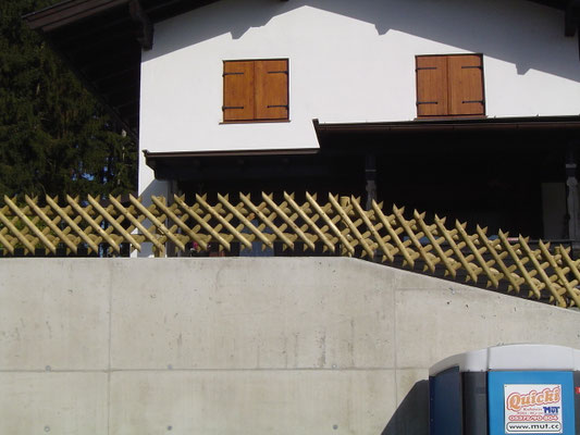 Zaun auf hoher Mauer mit Gefälle