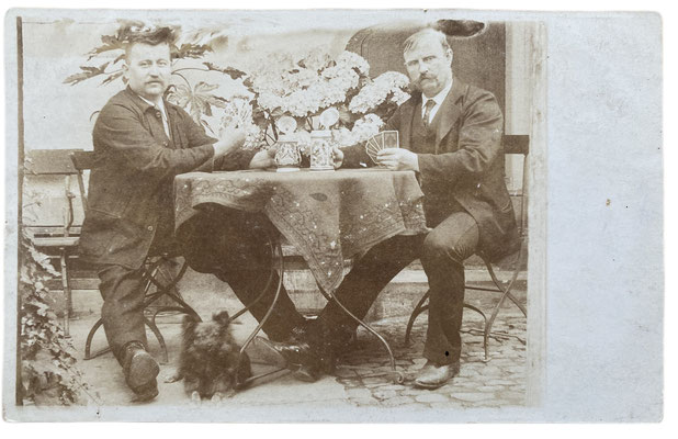 Two gentlemen with their Toy Spitz playing skat