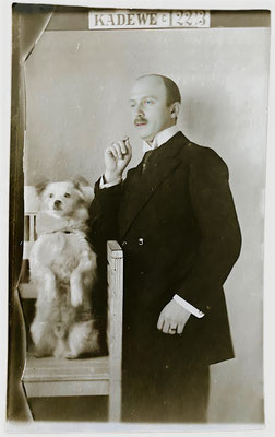 Ein Herr mit seinem weißen Spitz auf einem Foto aus dem Fotoatelier des Berliner KaDeWe