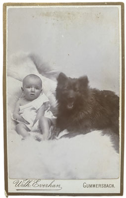 Schwarzer Spitz mit Säugling. Fotoatelier Wilhelm Everhan, Gummersbach. 