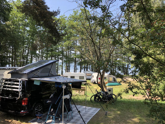 Unikat M-Platz 77 mit Blick auf die darunterliegenden Plätze unter Bäumen am See