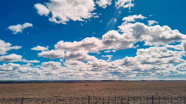 Wolken leicht rosé durch die Busfenster farbverfälscht