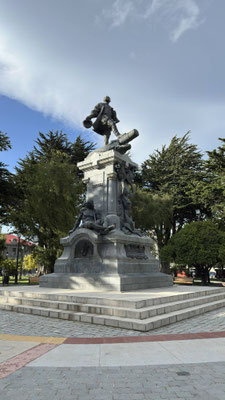 mit dem Denkmal von Magellan und symbolisch unter ihm unterdrückt liegenden Indigenen