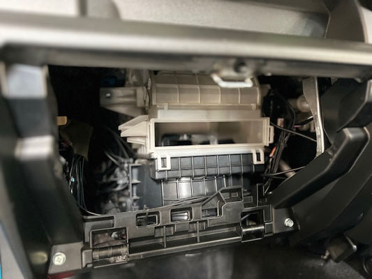 車内に染みついたタバコ臭を軽減するため、シートや内装を清掃している作業写真。