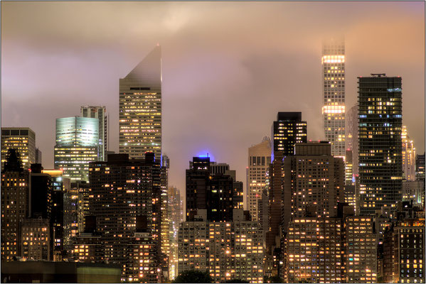 La nebbia lambisce le cime dei grattacieli di Manhattan e si tinge dei colori della città - © Massimo Vespignani