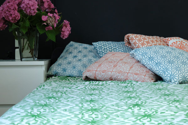 Geometric patterned organic cotton blanket on a bed, handprinted in Delhi, India by Maasa Production Pvt. Ltd.