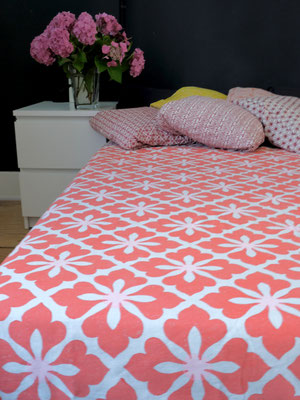 Marvel at the intricate craftsmanship of a blockprinted organic cotton blanket, made in Delhi, India, adding elegance to a bed.