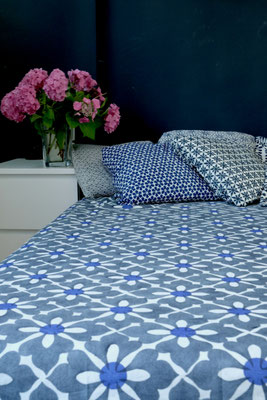 Marvel at the intricate craftsmanship of a blockprinted organic cotton blanket, made in Delhi, India, adding elegance to a bed.