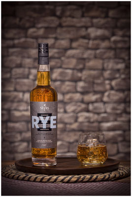Rye Whisky Flasche und Glas vor Stein wand