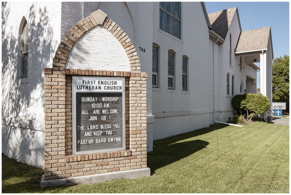 Kirche mit verwittertem Schild – Spuren der Zeit prägen das Bild