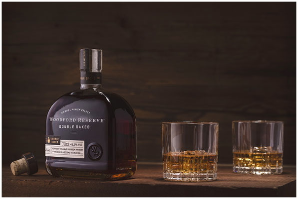 Woodford Reserve Bourbon Flasche mit Glas stylisch ins Licht gesetzt