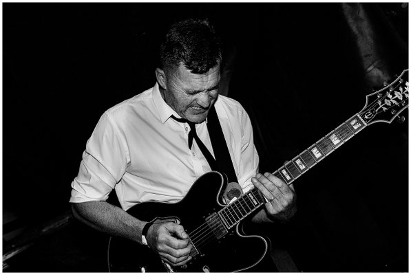 Gitarrist in Bewegung – monochromes Bild voller Rhythmus und Energie.