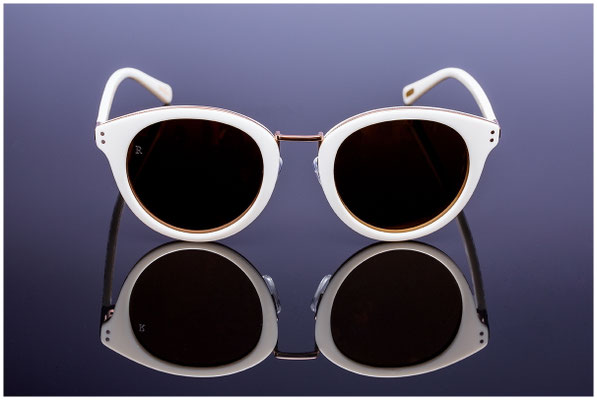 Sonnebrille mit Rahmen in weiss auf schwarzem Hintergrund