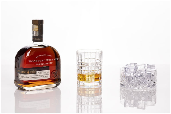 Woodford Reserve Bourbon stylisch auf weisser Glasplatte ins Licht gesetzt