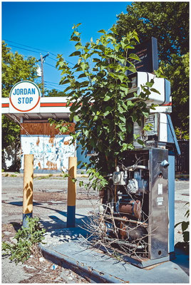 Verfallene Zapfsäule – von Pflanzen überwuchert, Symbol für Vergänglichkeit.